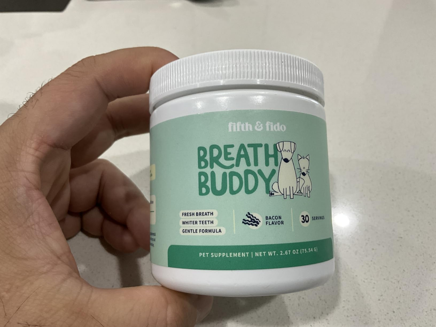 A customer holding a tub of the dental powder