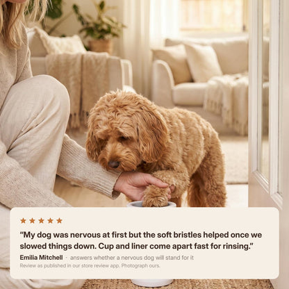 A dog having a paw washed at the door, with a review about a nervous first go and how fast the cup and liner come apart