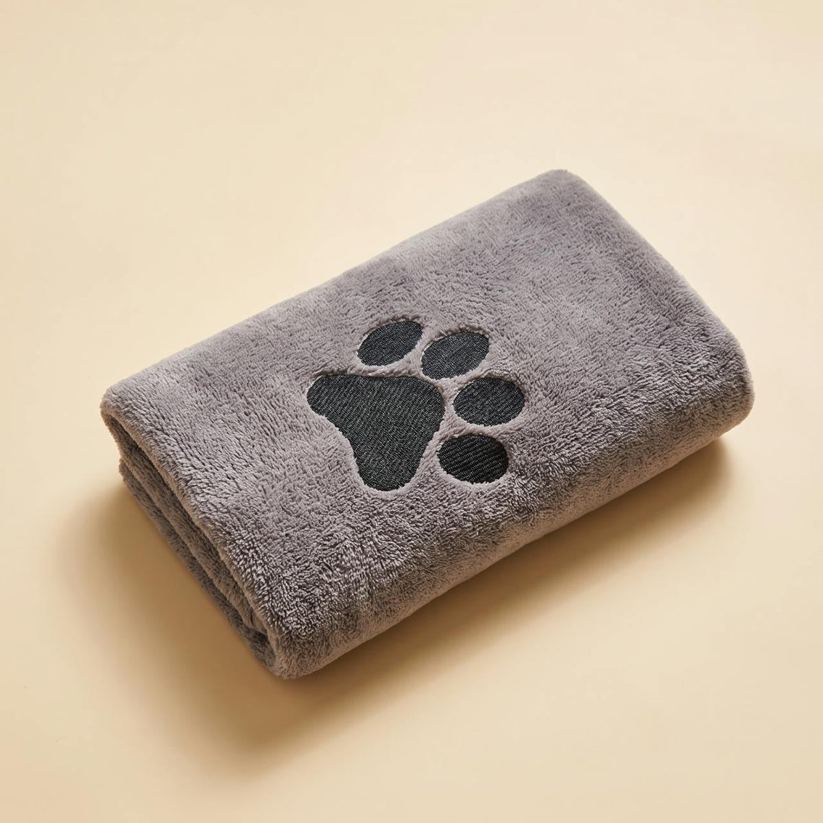 The Sidekick Doorstep Drying Towel folded, showing the embroidered paw